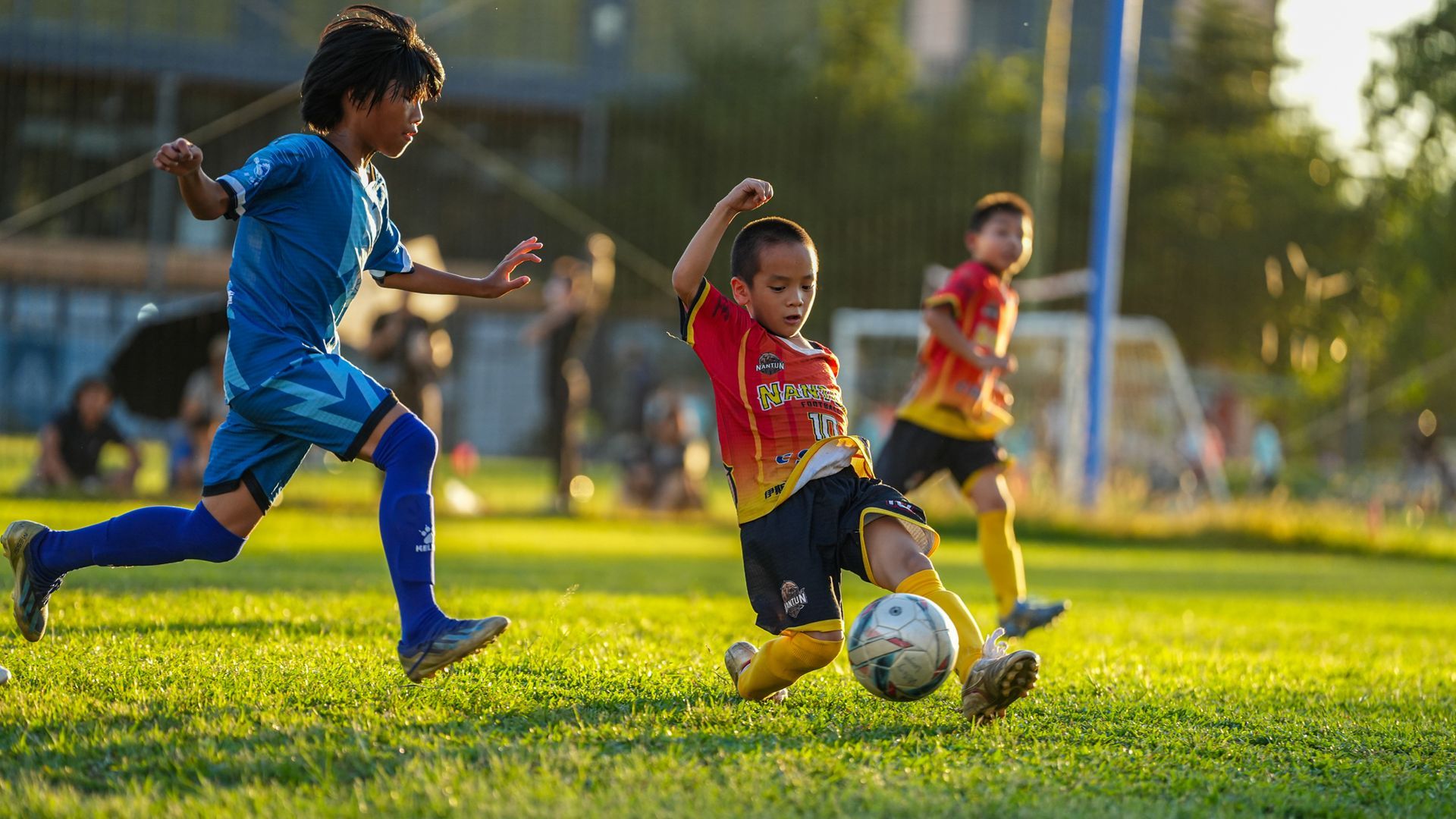 一群小男孩正在操場上踢足球。