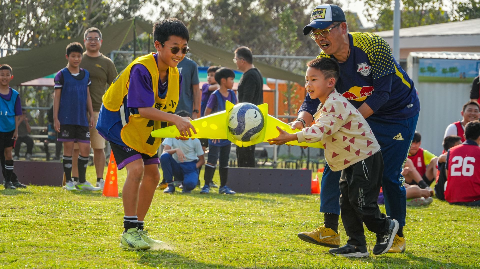 一個男人和一個男孩正在球場上踢足球。