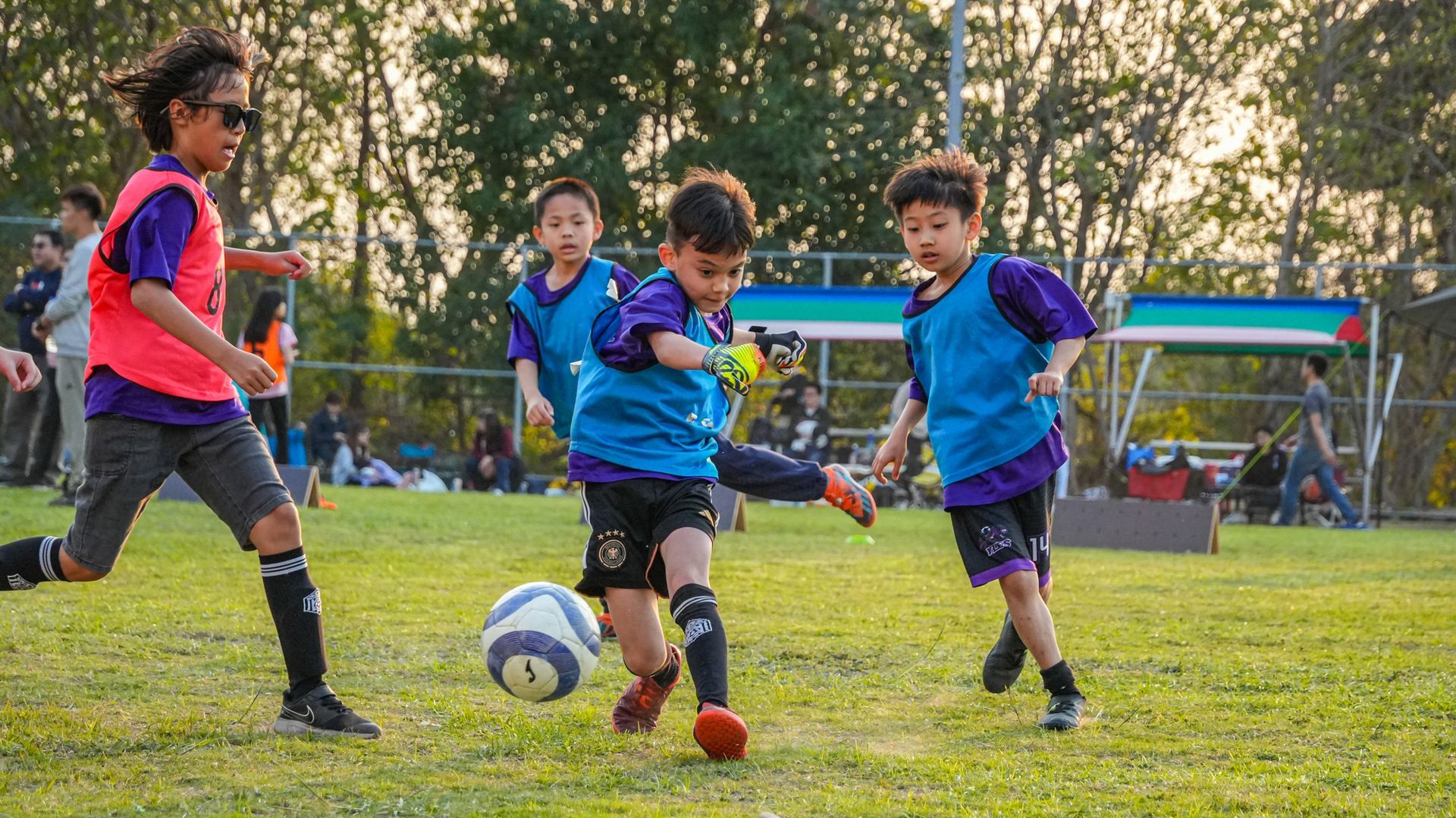 一群小男孩正在操場上踢足球。