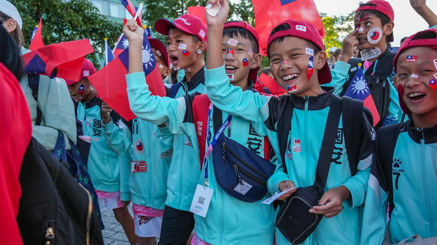 一群臉上畫著旗幟的孩子並排站著。