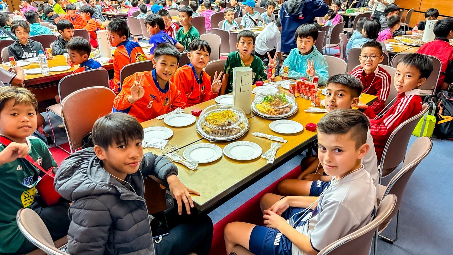 一群孩子坐在一張桌子旁，桌上擺滿了食物。