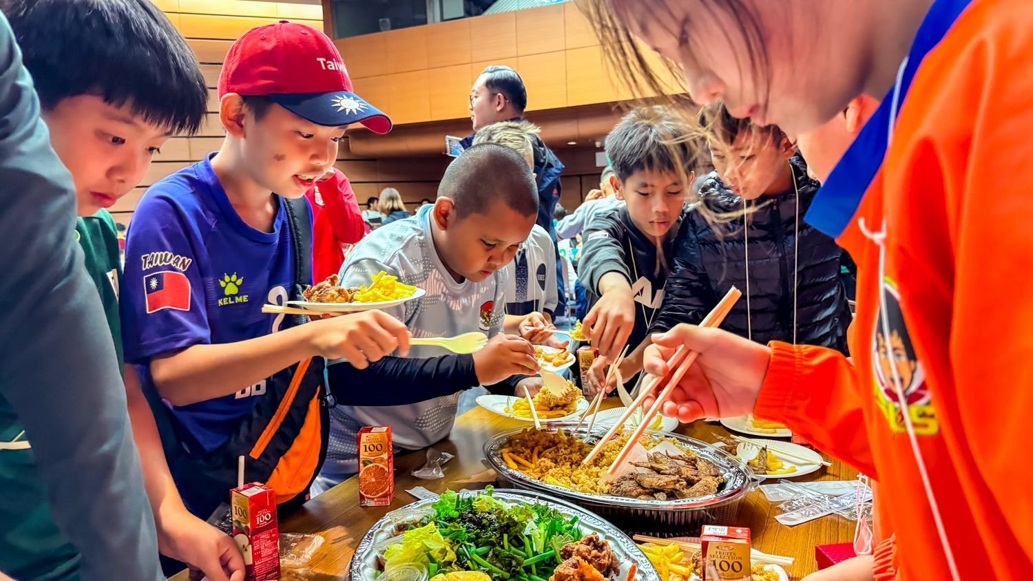 一群孩子圍坐在桌子旁吃食物。