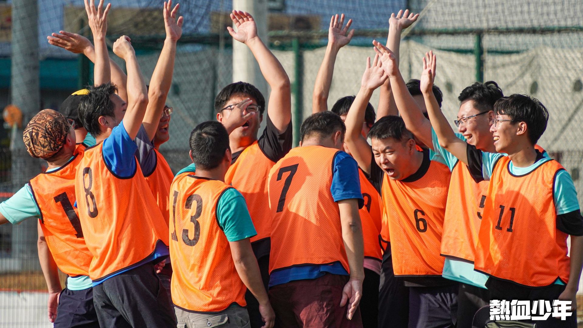 一群年輕人站成一團，雙臂舉在空中。