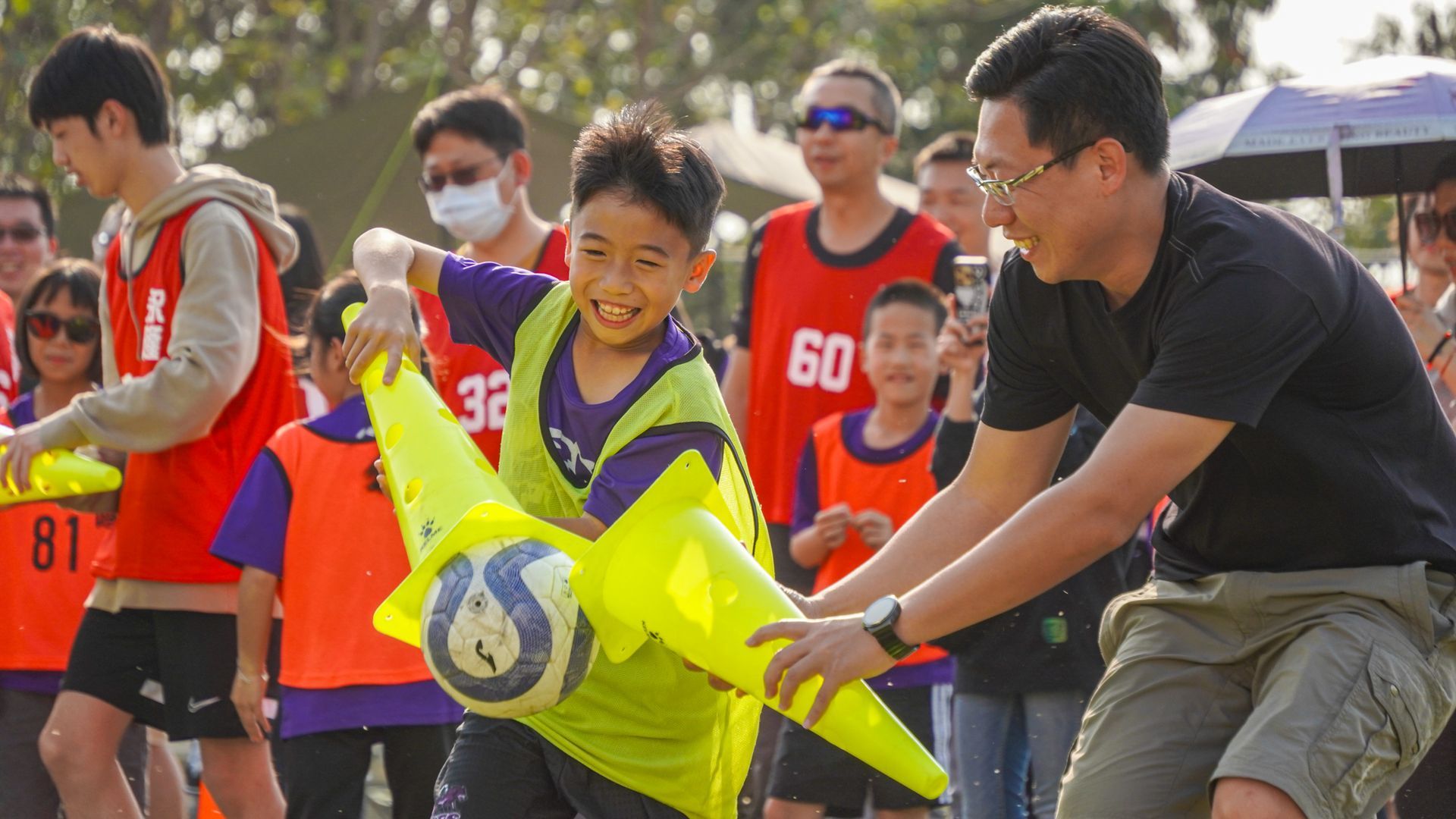 一個小男孩正在網球場上打網球。