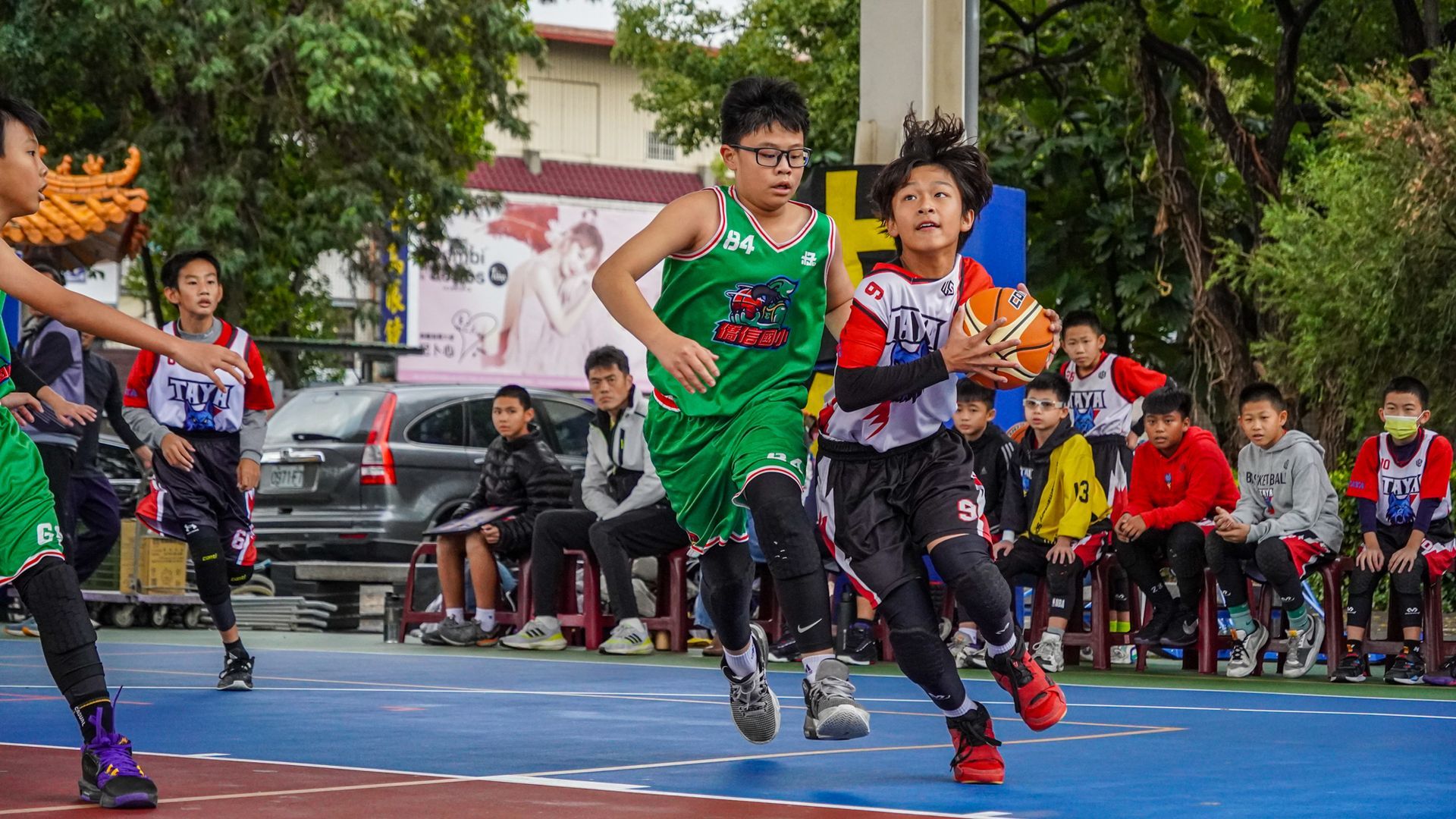 一群小男孩正在球場上打籃球。