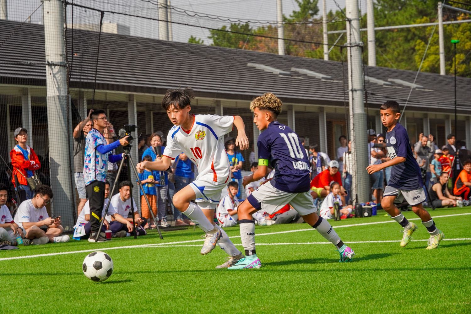 一群小男孩正在操場上踢足球。