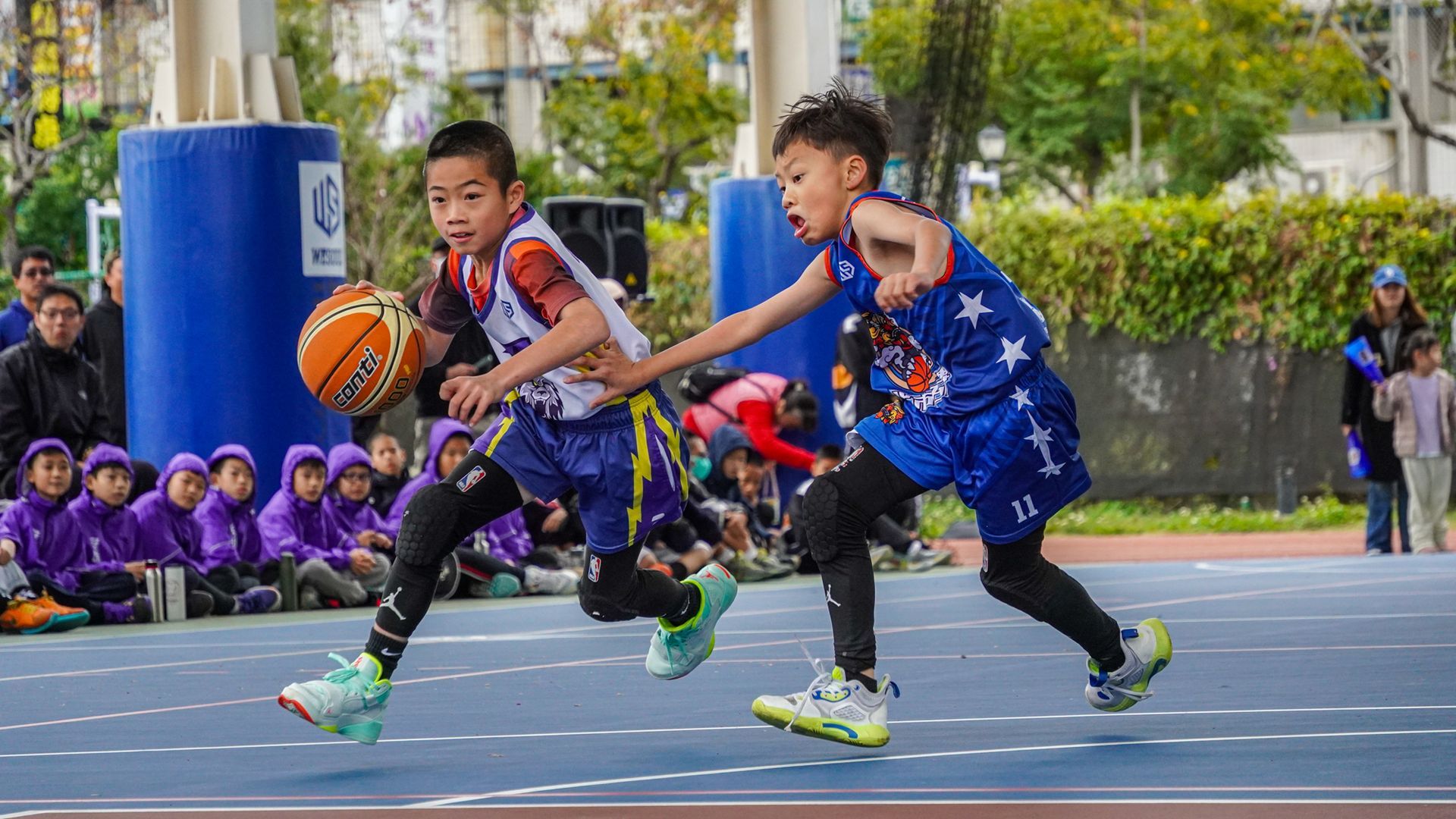 兩個小男孩正在球場上打籃球。