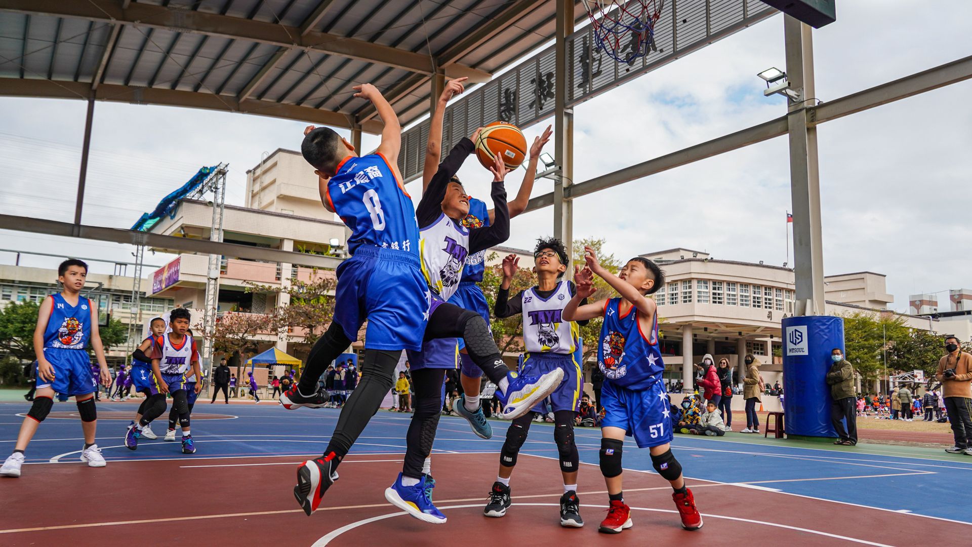 一群小男孩正在球場上打籃球。