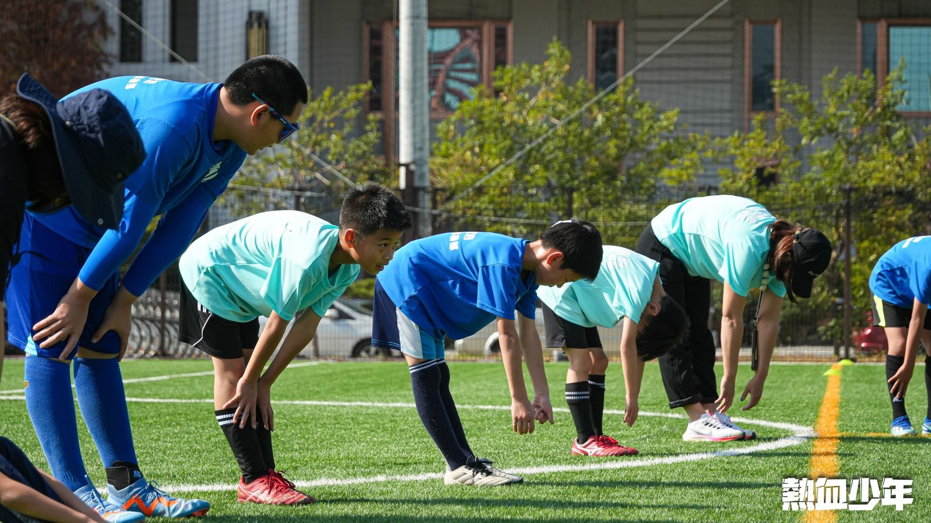 一群人正在足球場上伸展身體。