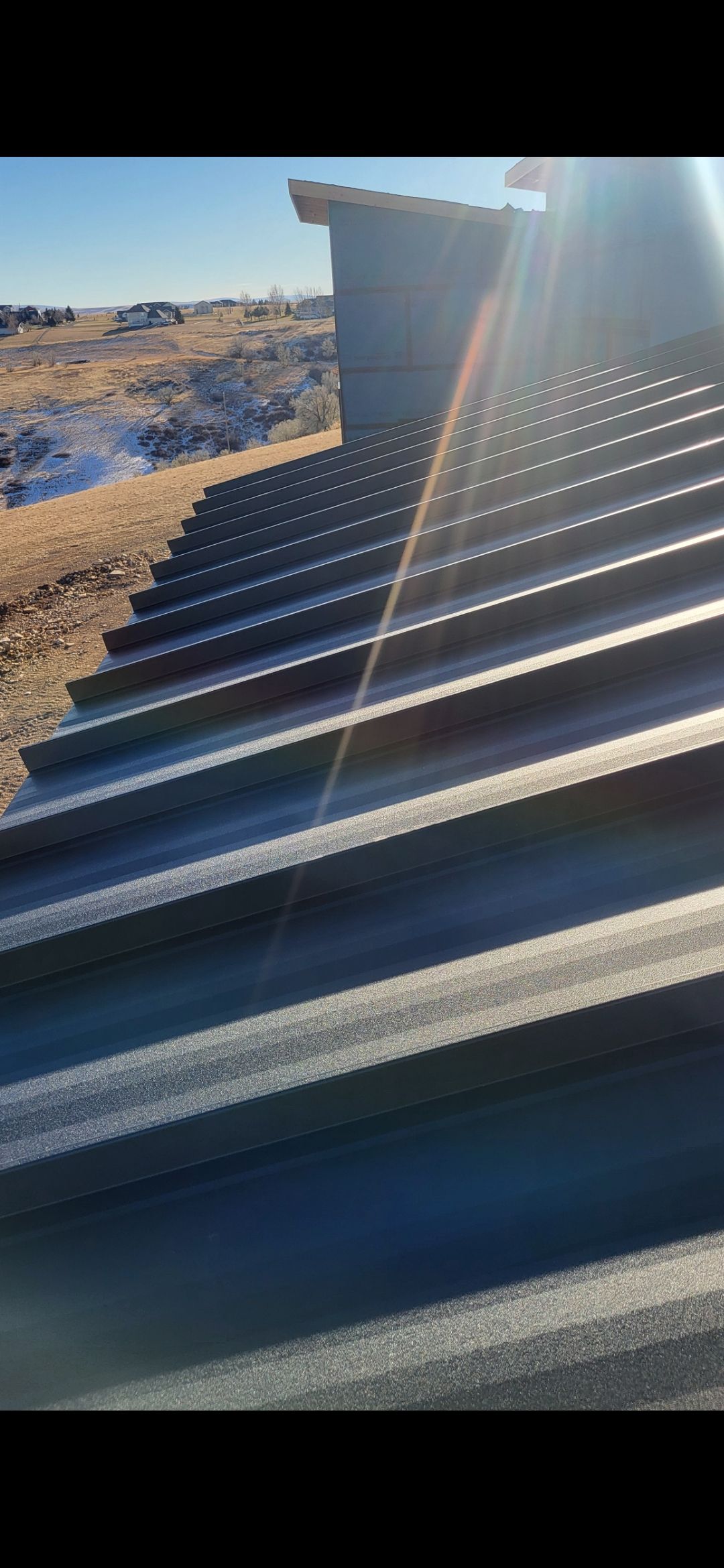 A close-up of a corrugated metal roof on a sunny day.
