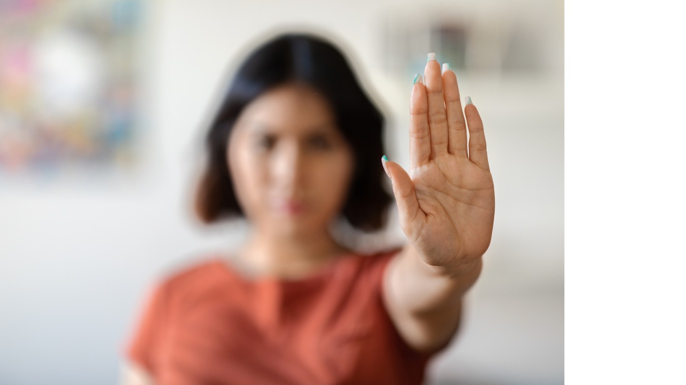 A woman is making a stop sign with her hand.