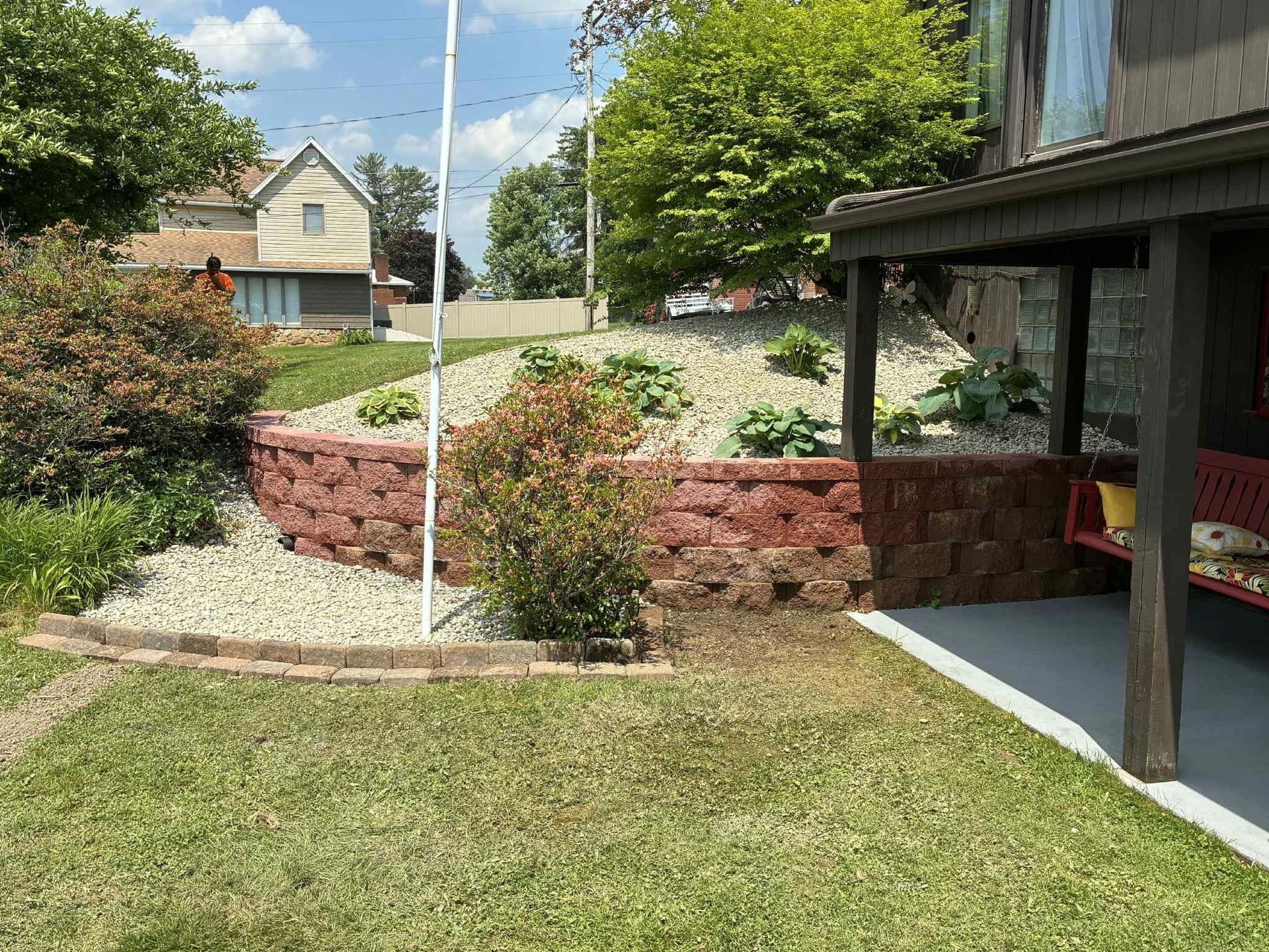 There is a flag pole in the backyard of a house.