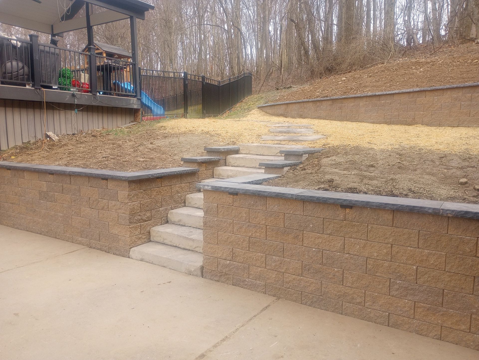 A brick wall with stairs leading up to a deck.