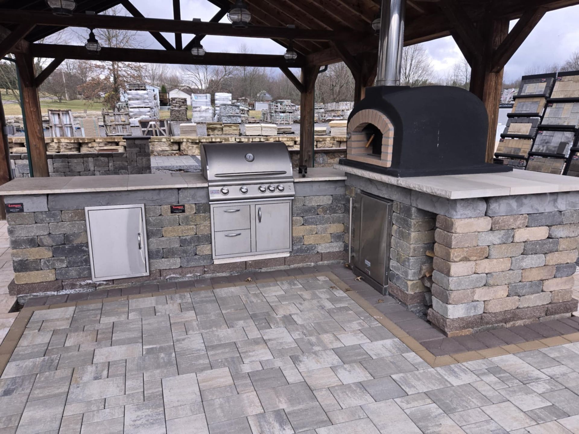 An outdoor kitchen with a pizza oven and a grill