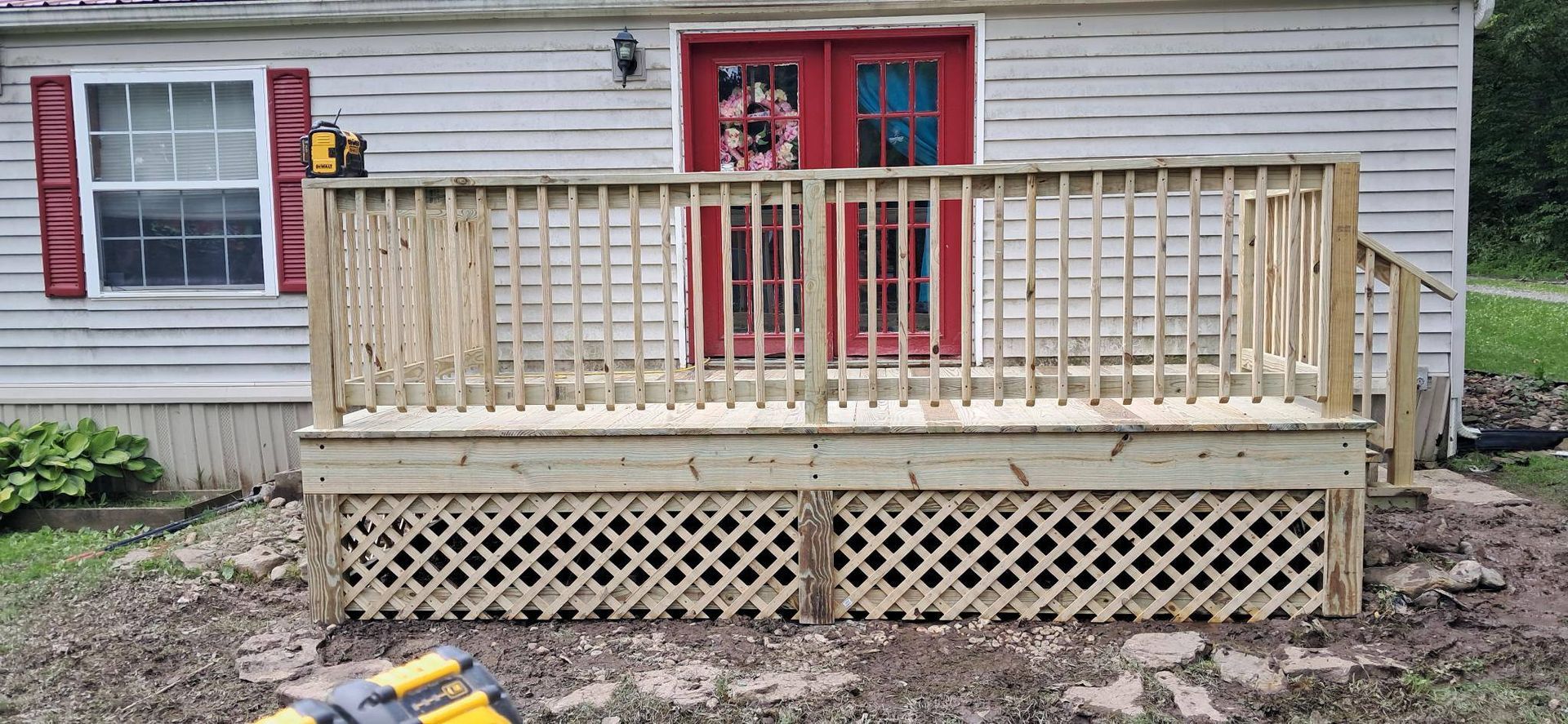 A wooden deck is being built in front of a house.