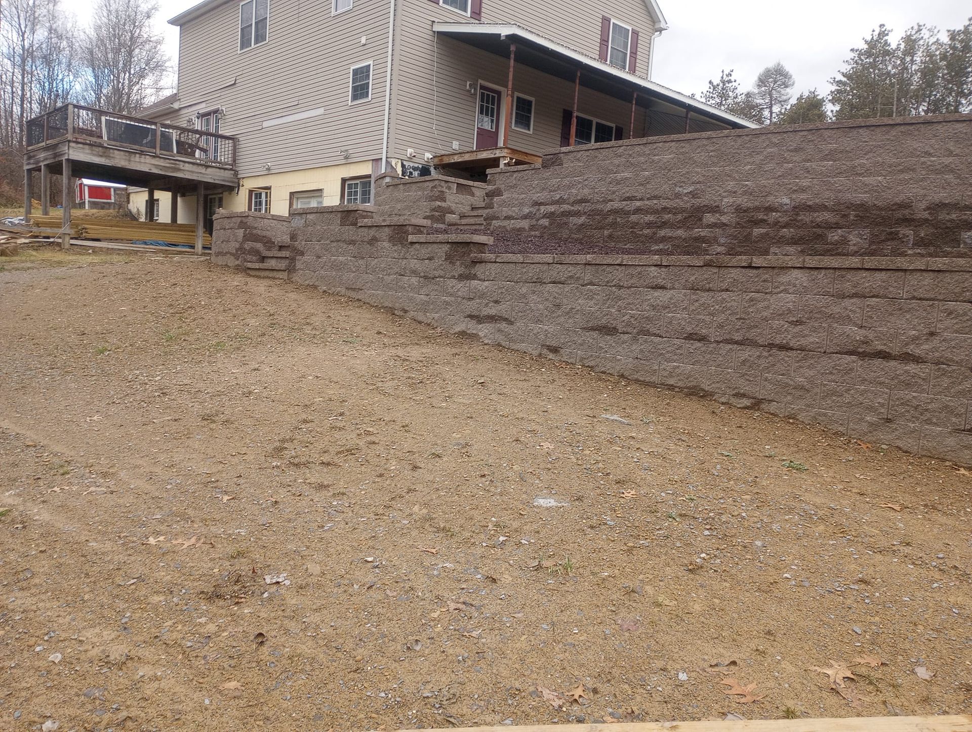 A large house with a large stone wall in front of it