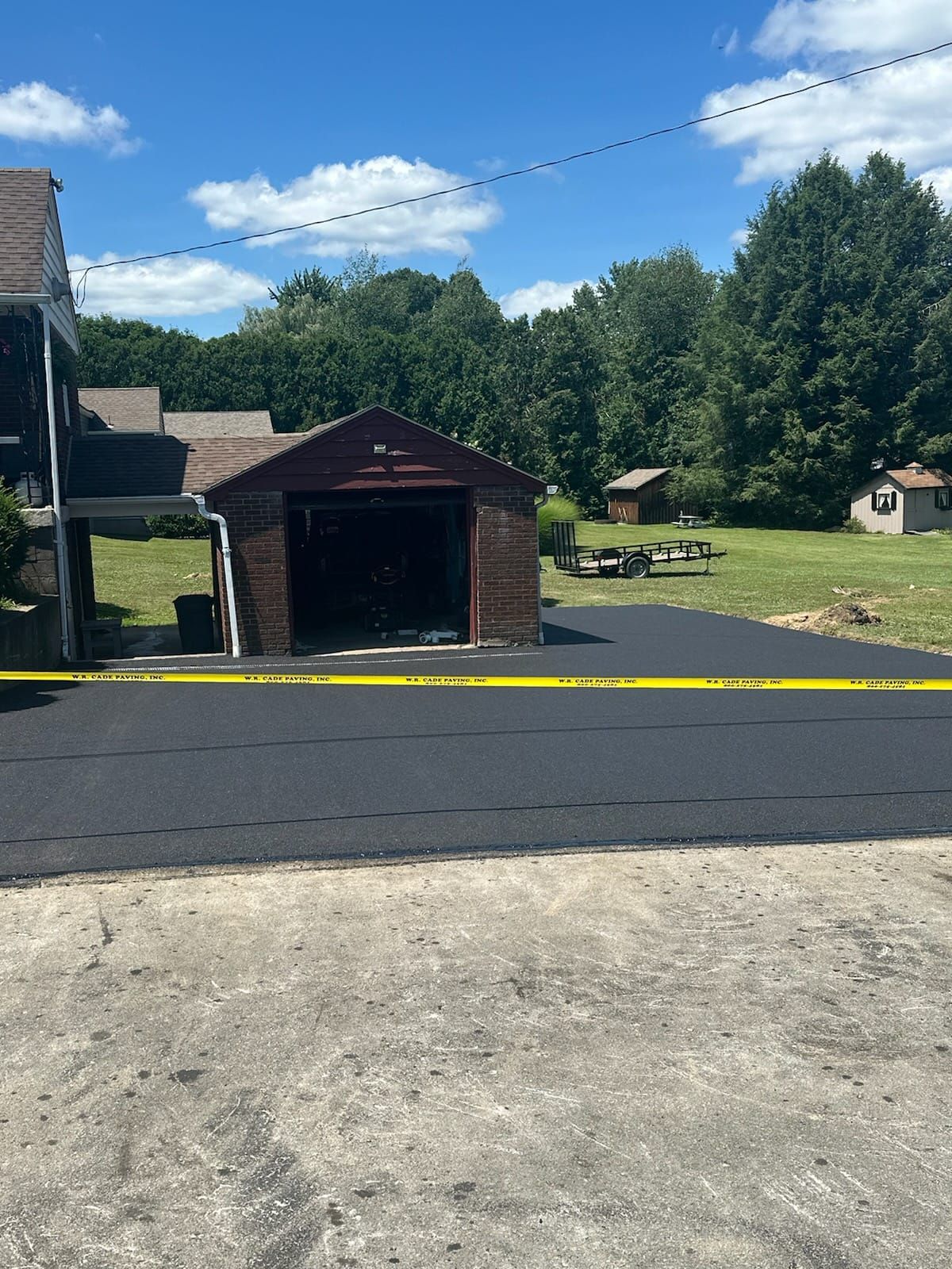 A driveway with a garage and a house in the background