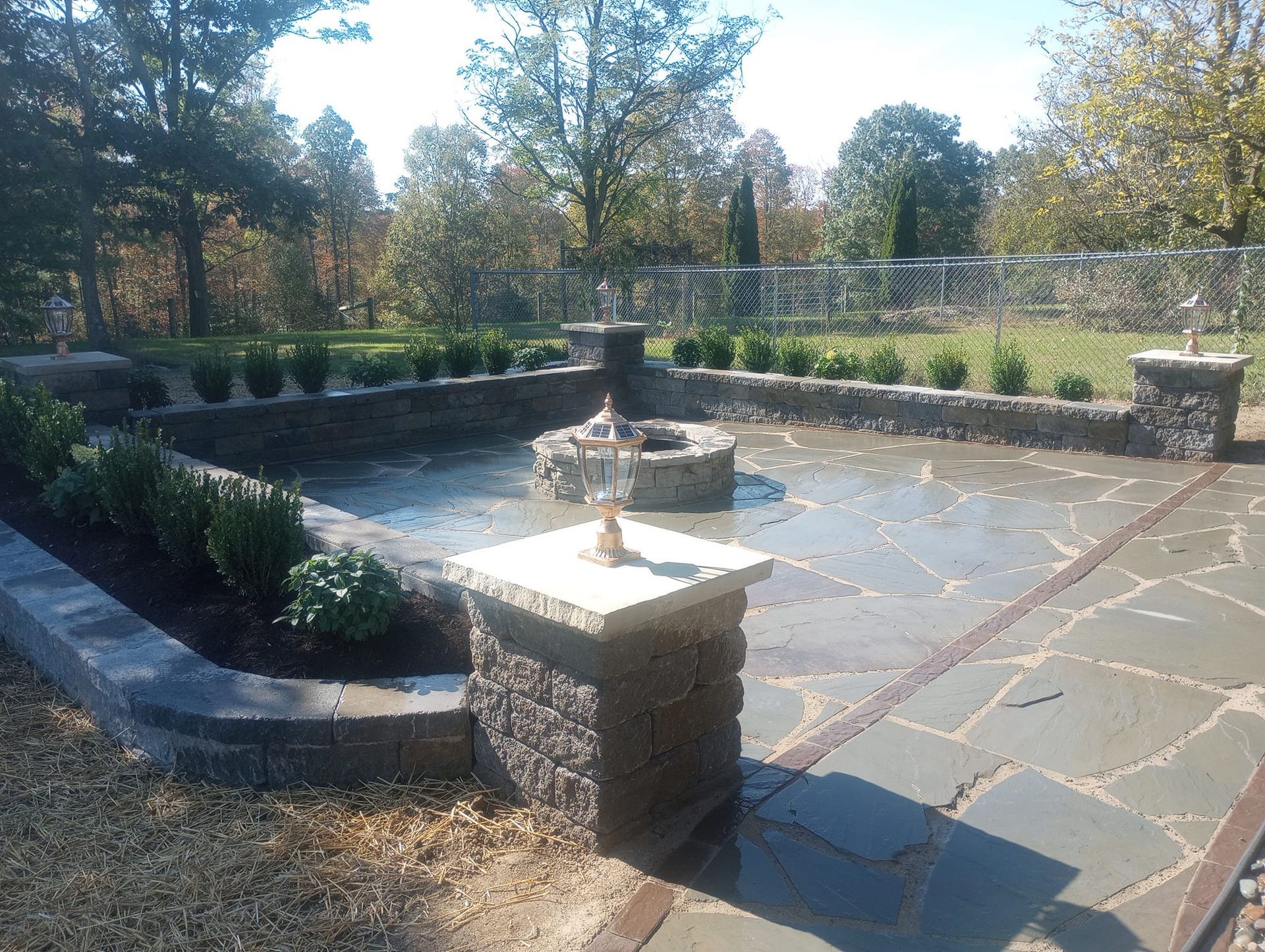 A stone patio with a fire pit in the middle