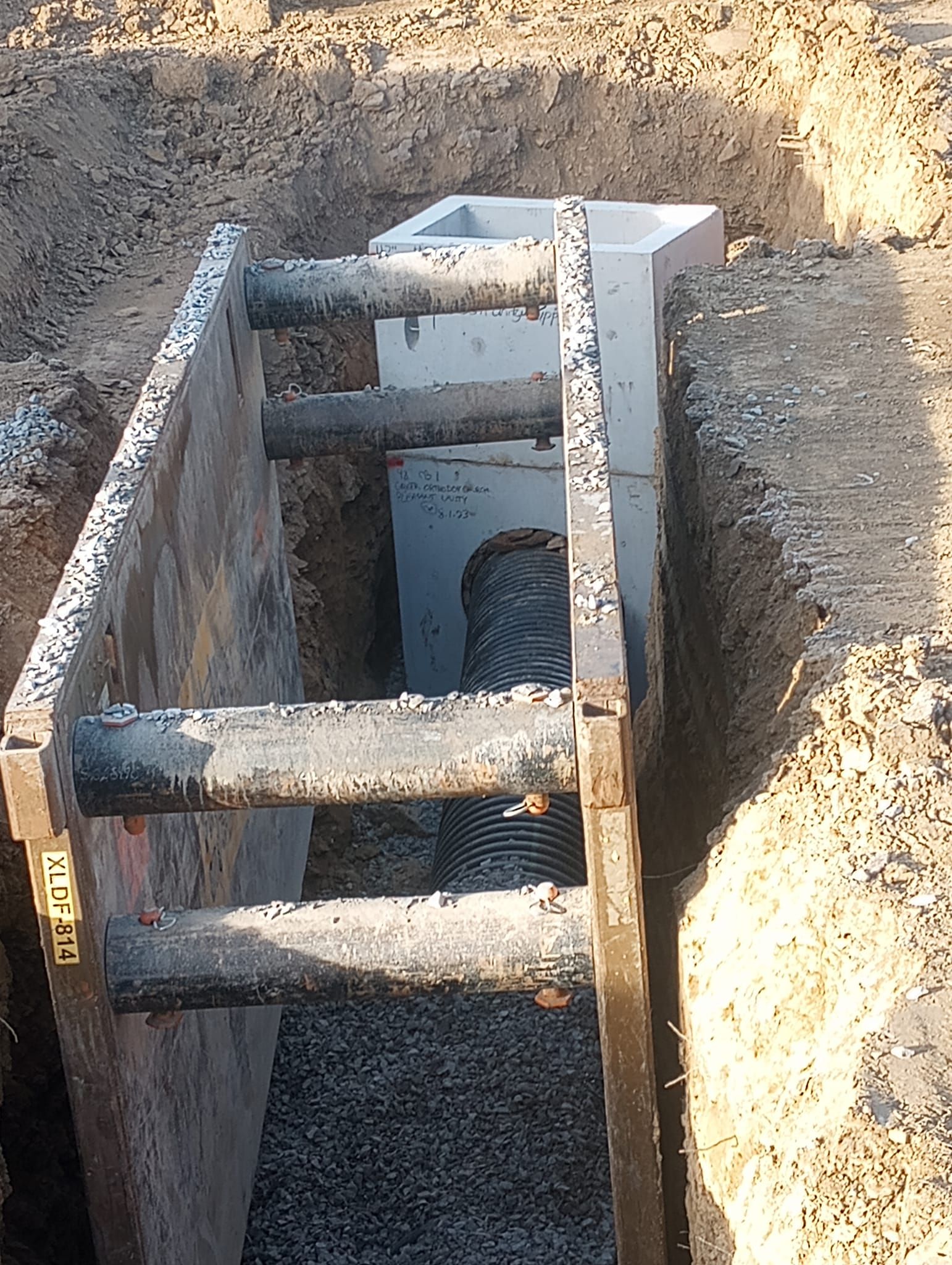 A hole in the ground with a concrete block in the middle of it.