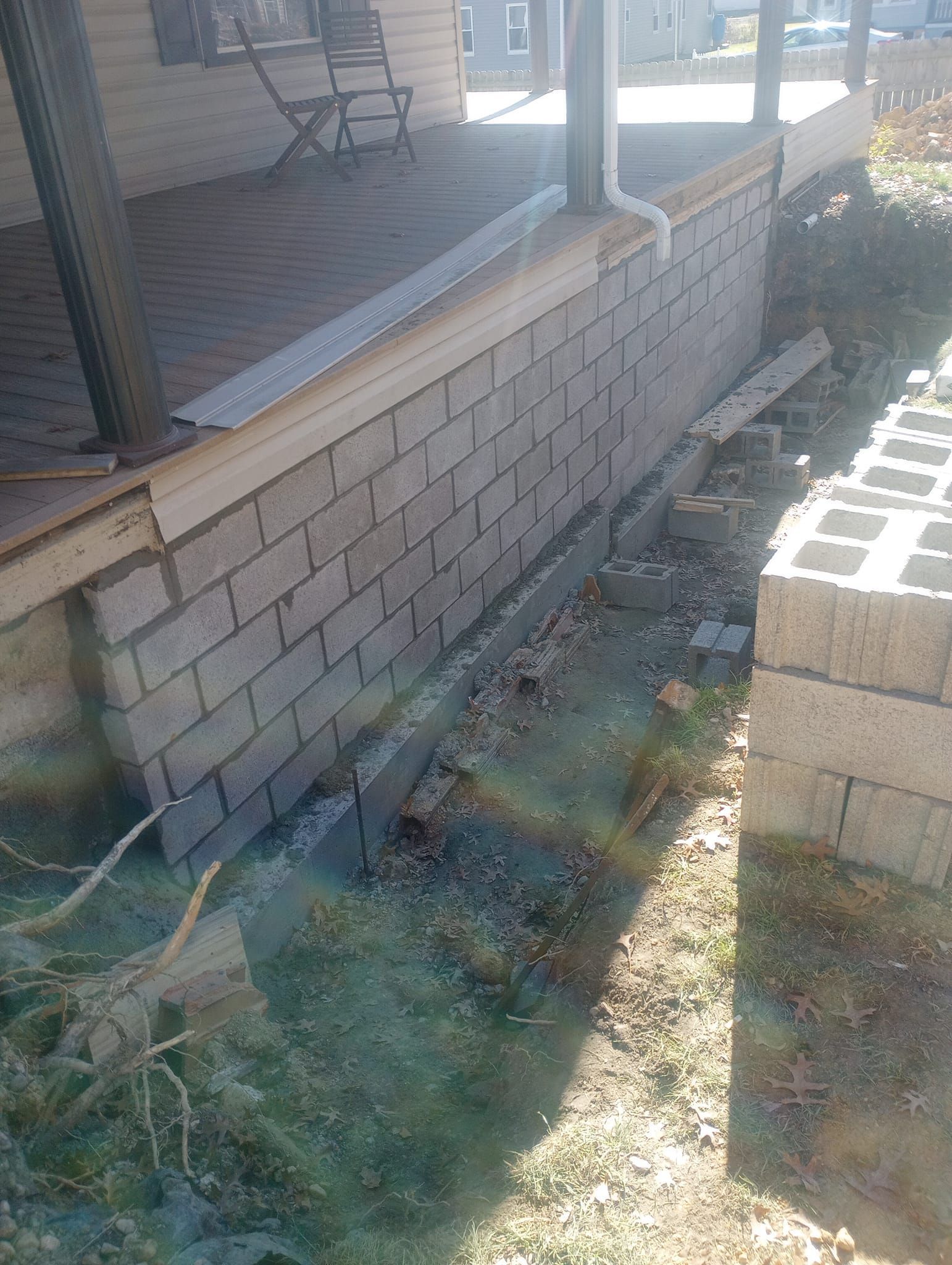 A brick wall is being built next to a porch.