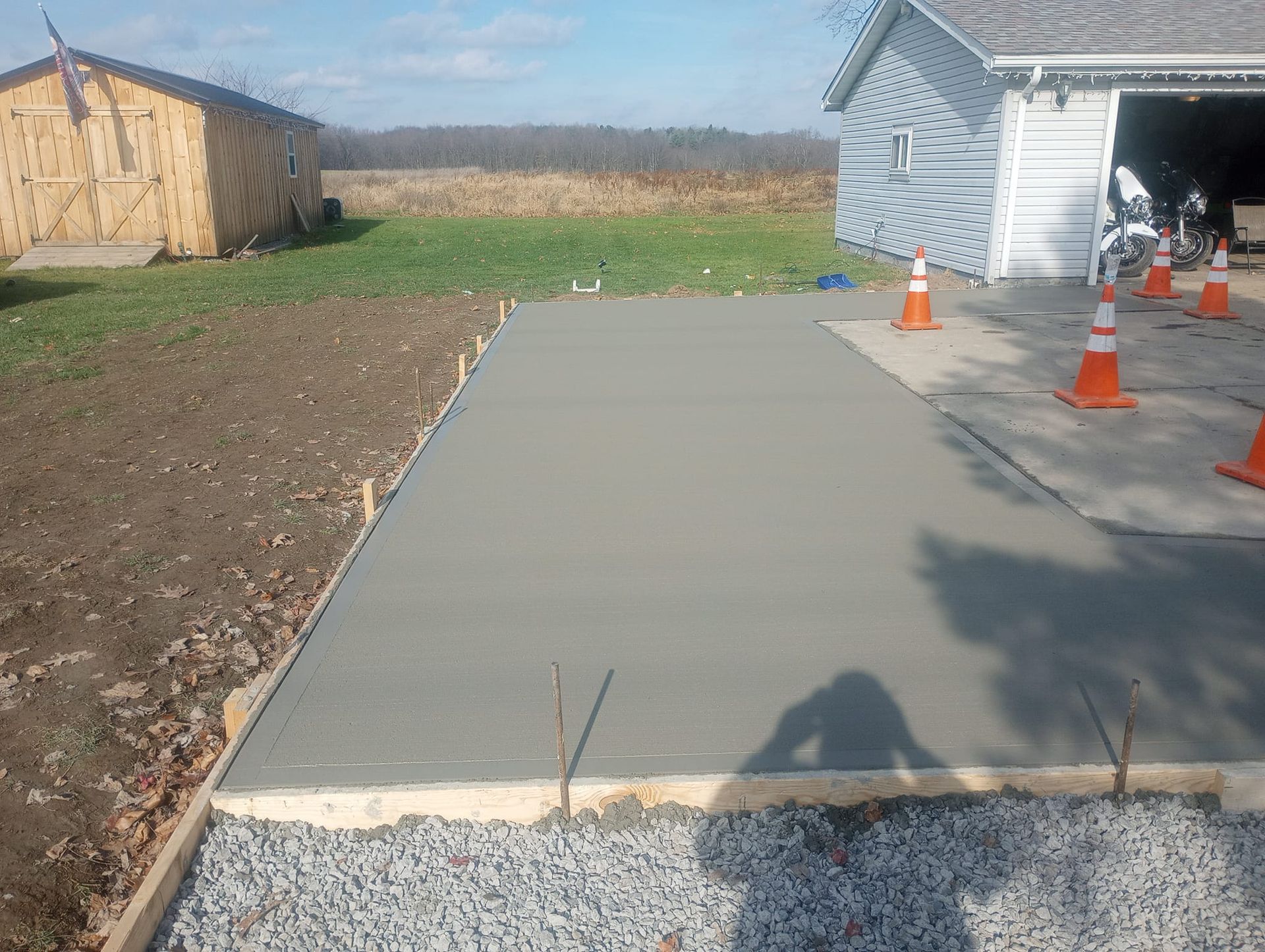 A concrete driveway is being built in front of a garage.