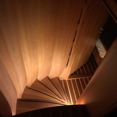 A spiral staircase made of wood is lit up at night