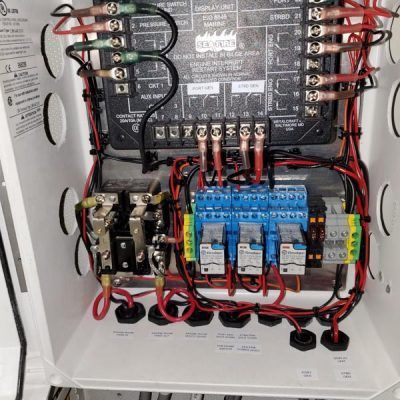 The inside of a electrical box with a lot of wires coming out of it.