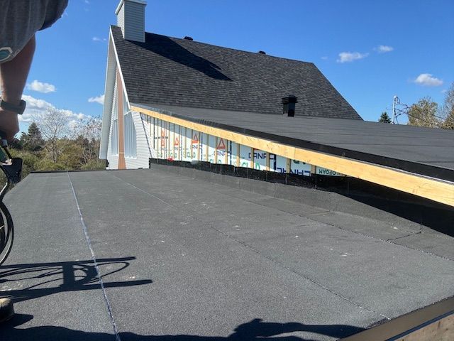 Une personne mesure un toit avec un ruban à mesurer