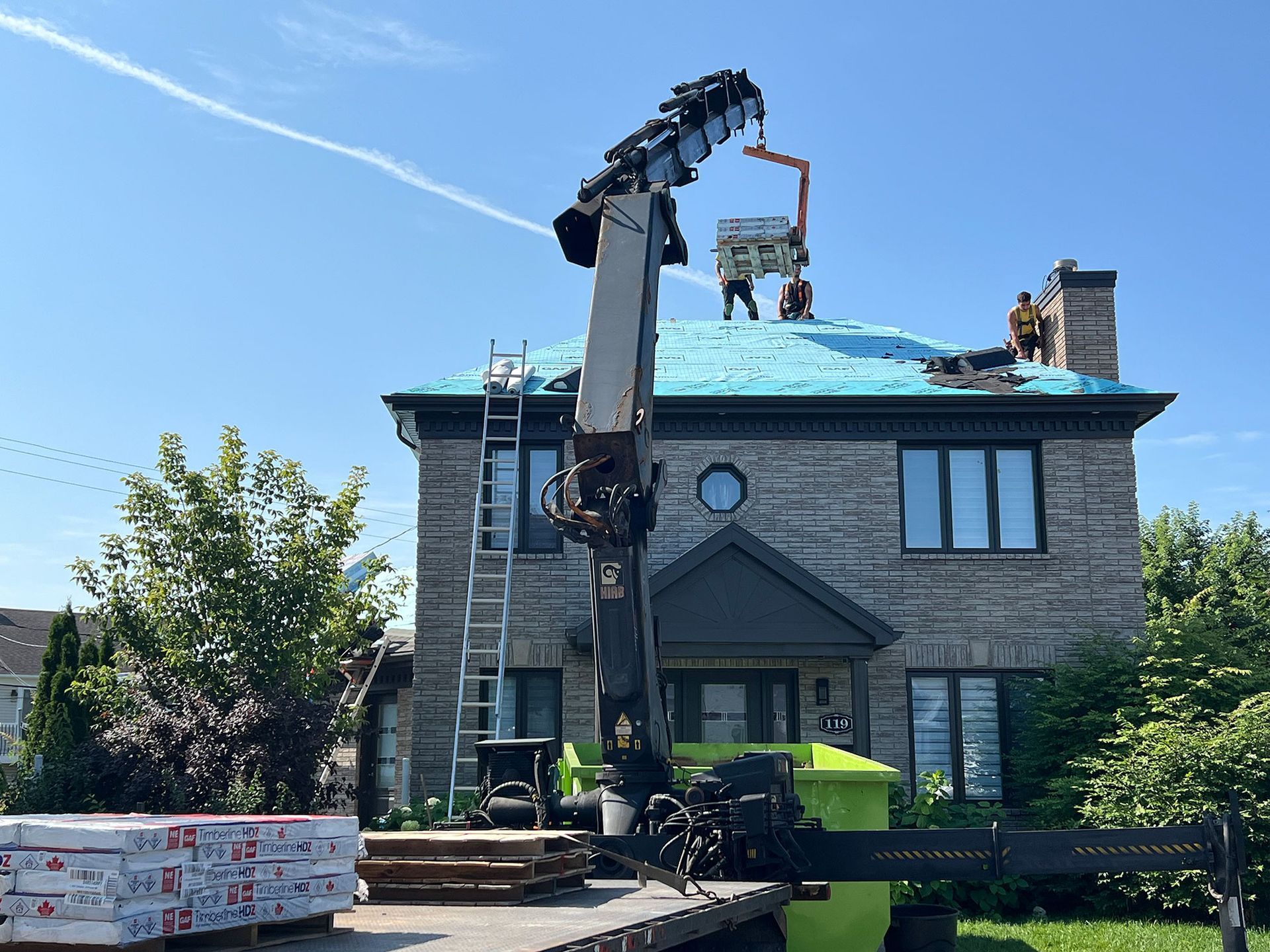 Une grue est utilisée pour installer un toit sur une maison.