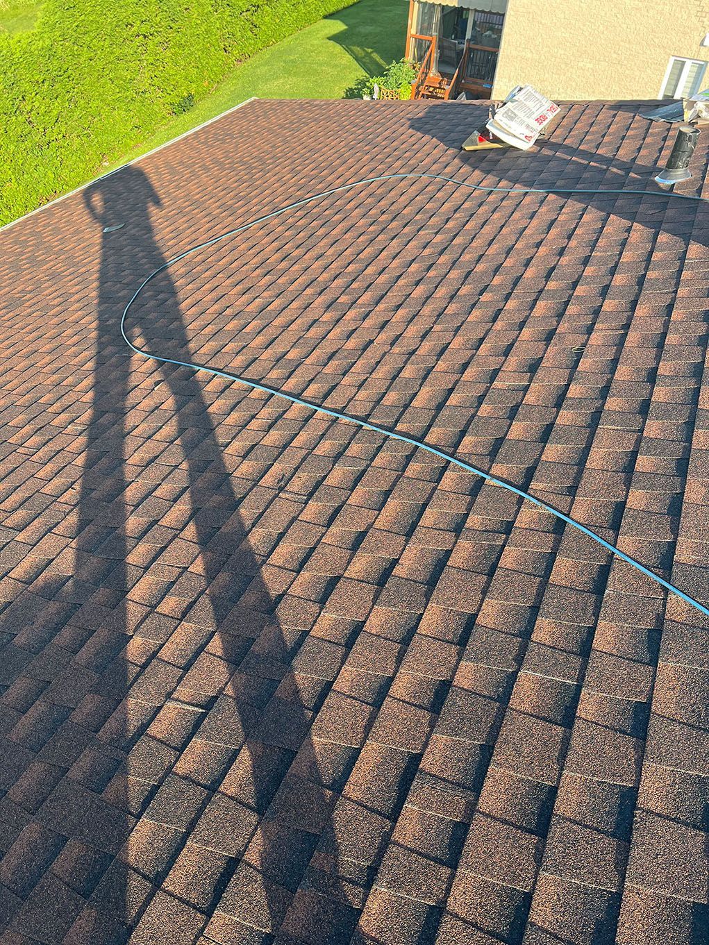 L'ombre d'une personne est projetée sur le toit d'une maison.