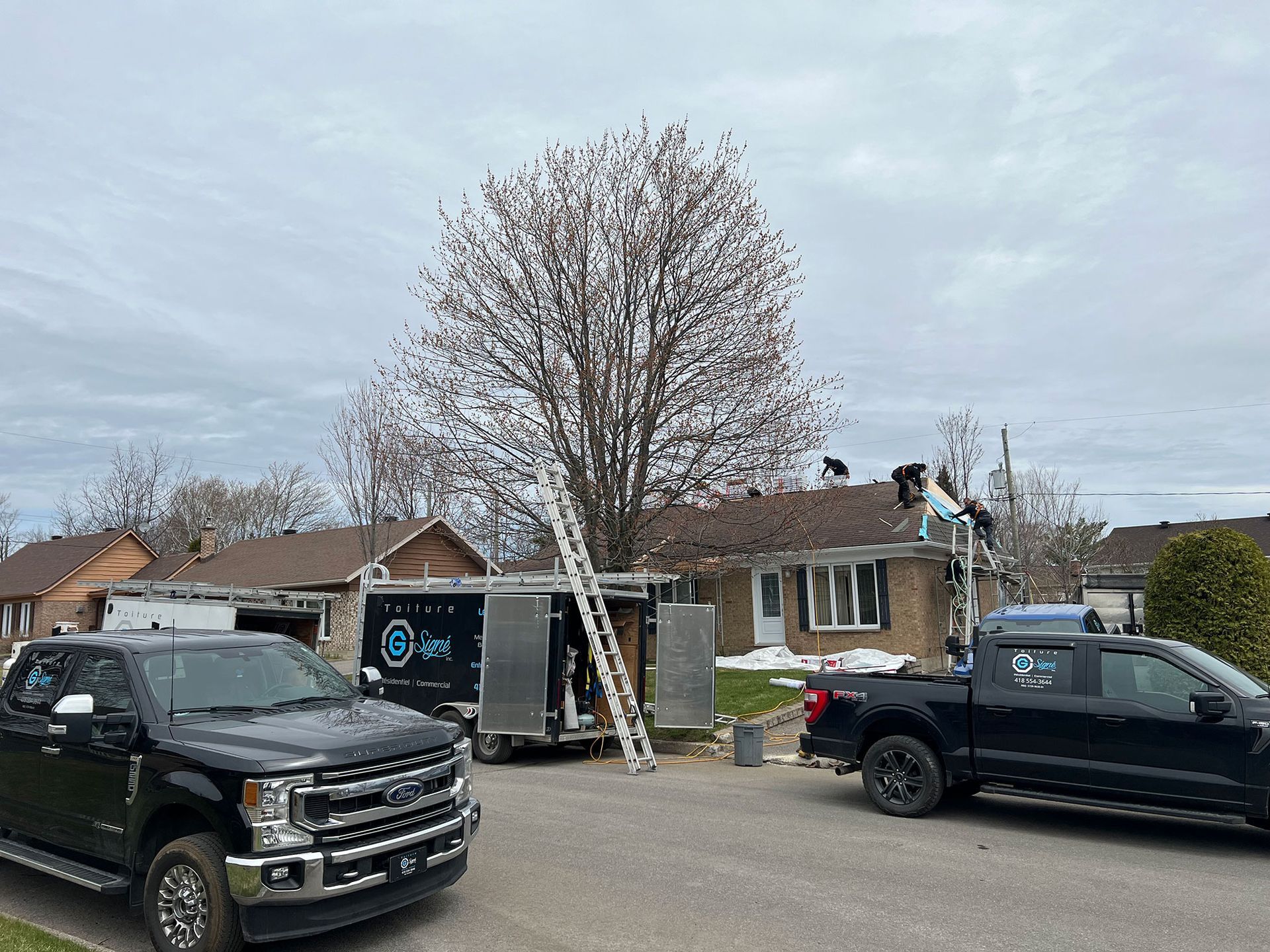 Quelques camions garés devant une maison.