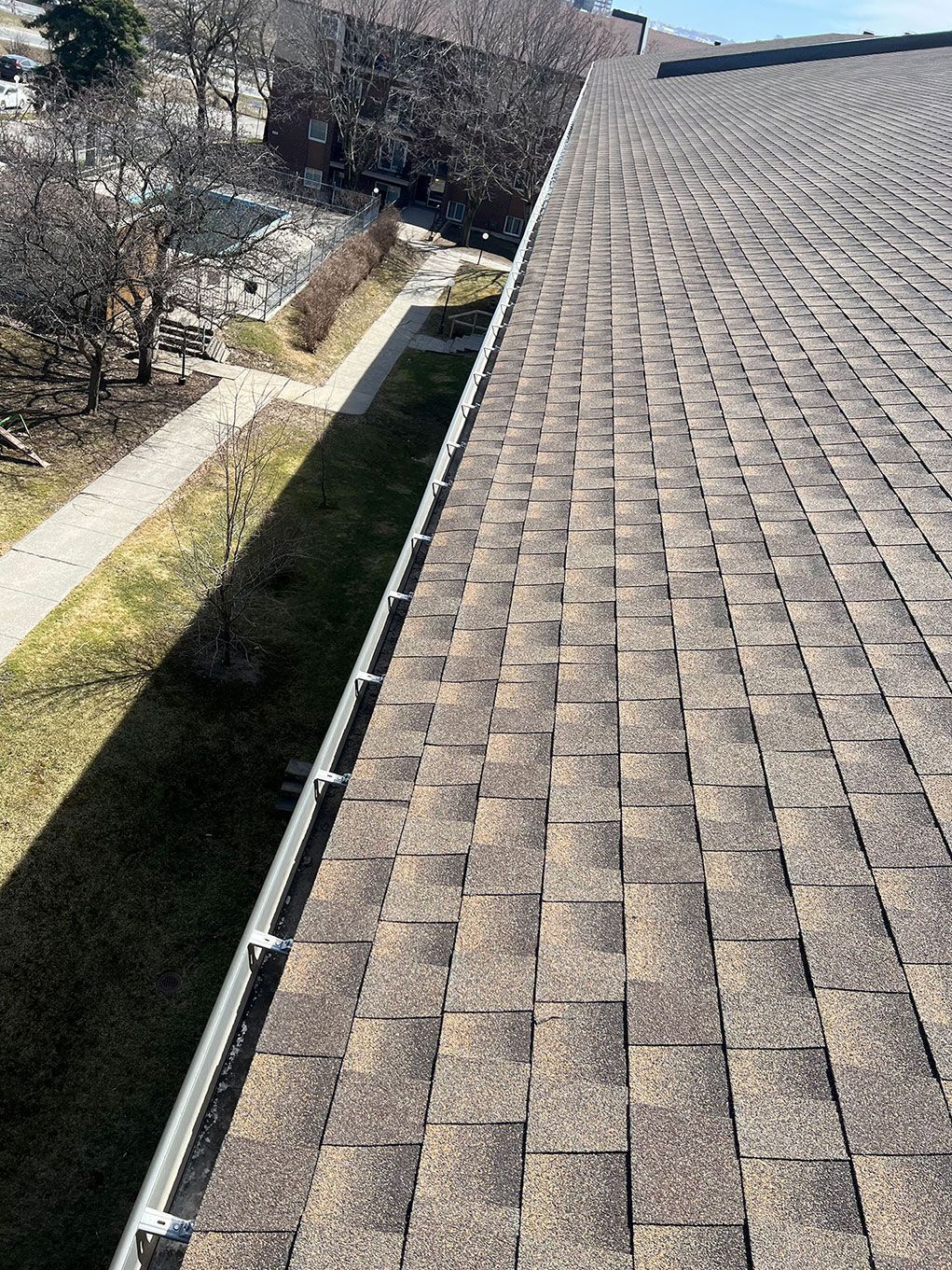 Un gros plan d'un toit avec une gouttière dessus.