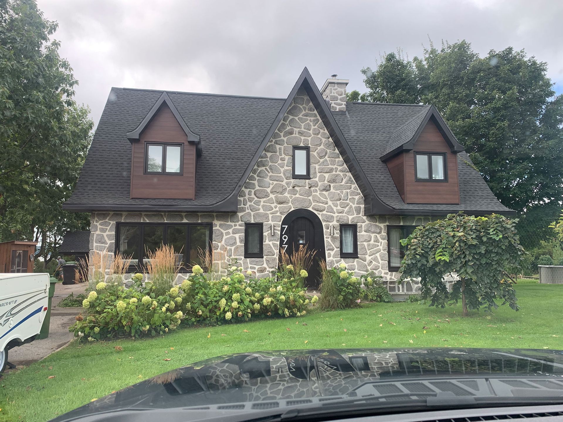 Une grande maison en pierre avec un toit noir