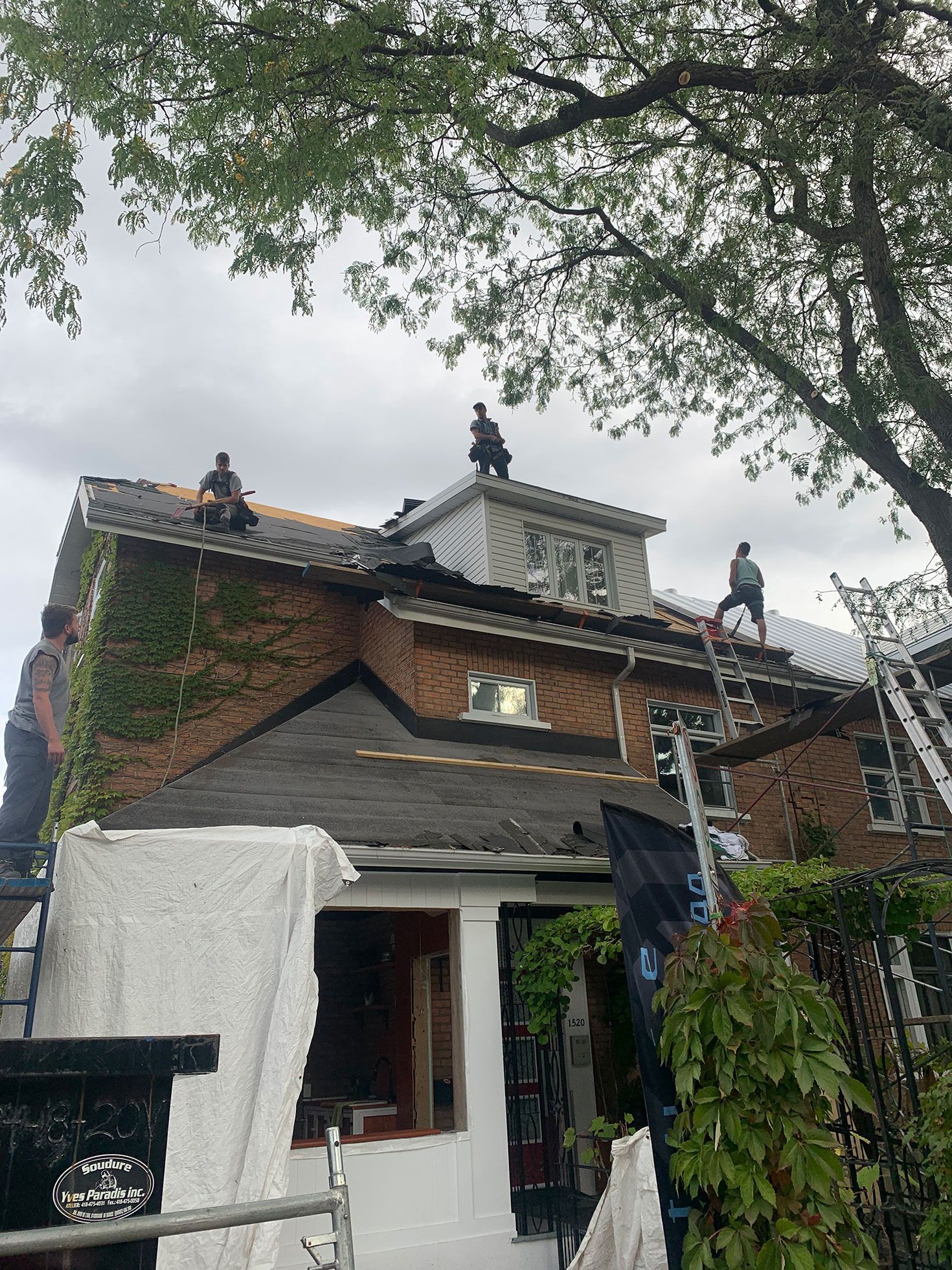 Un groupe de personnes travaille sur le toit d'une maison.