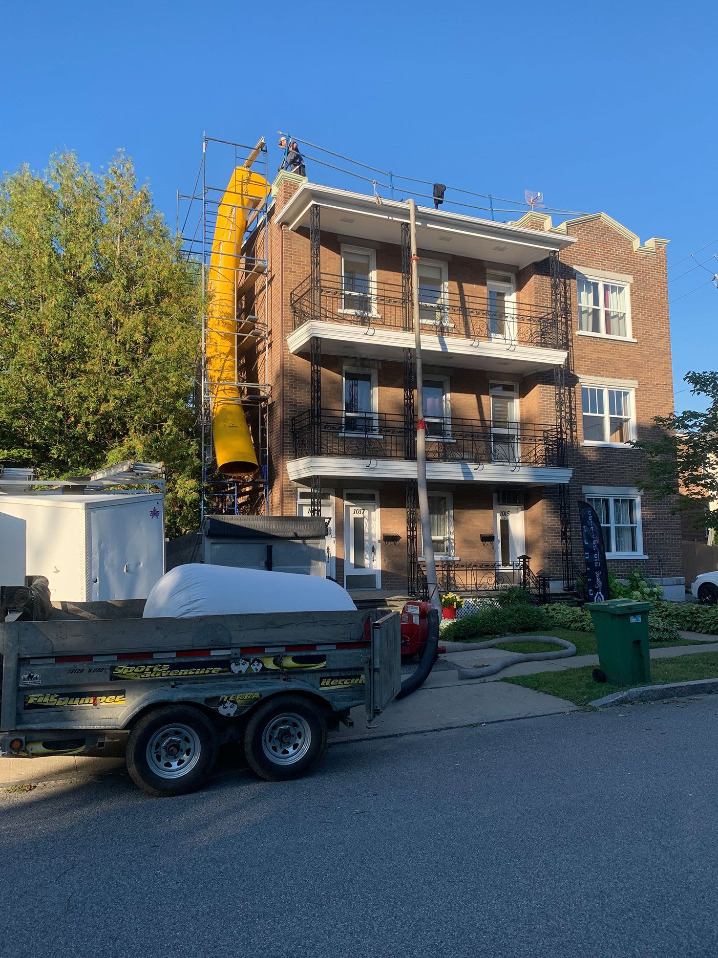 Une remorque est garée devant un grand bâtiment en briques.