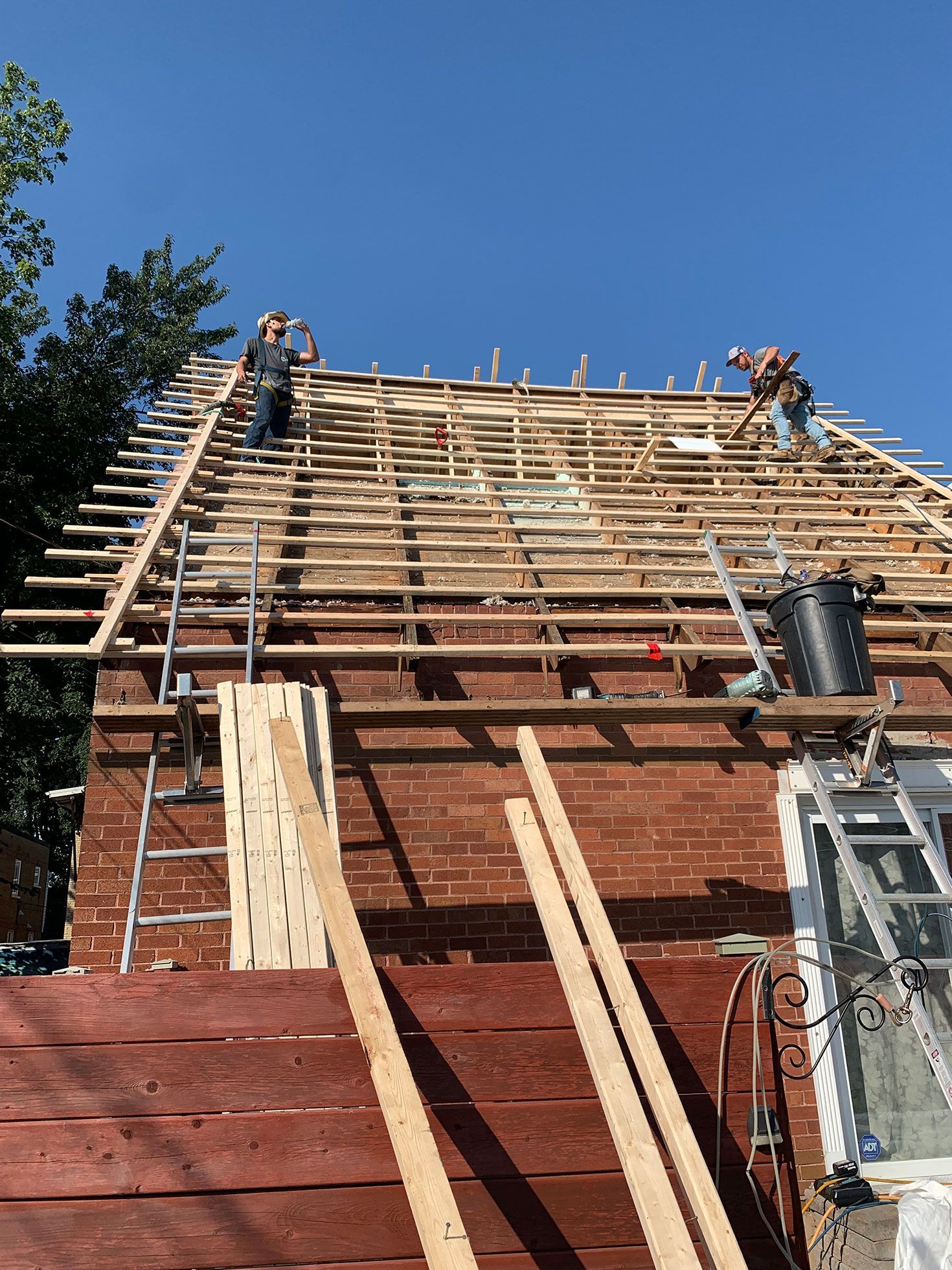 Un groupe d'ouvriers du bâtiment travaille sur le toit d'une maison.