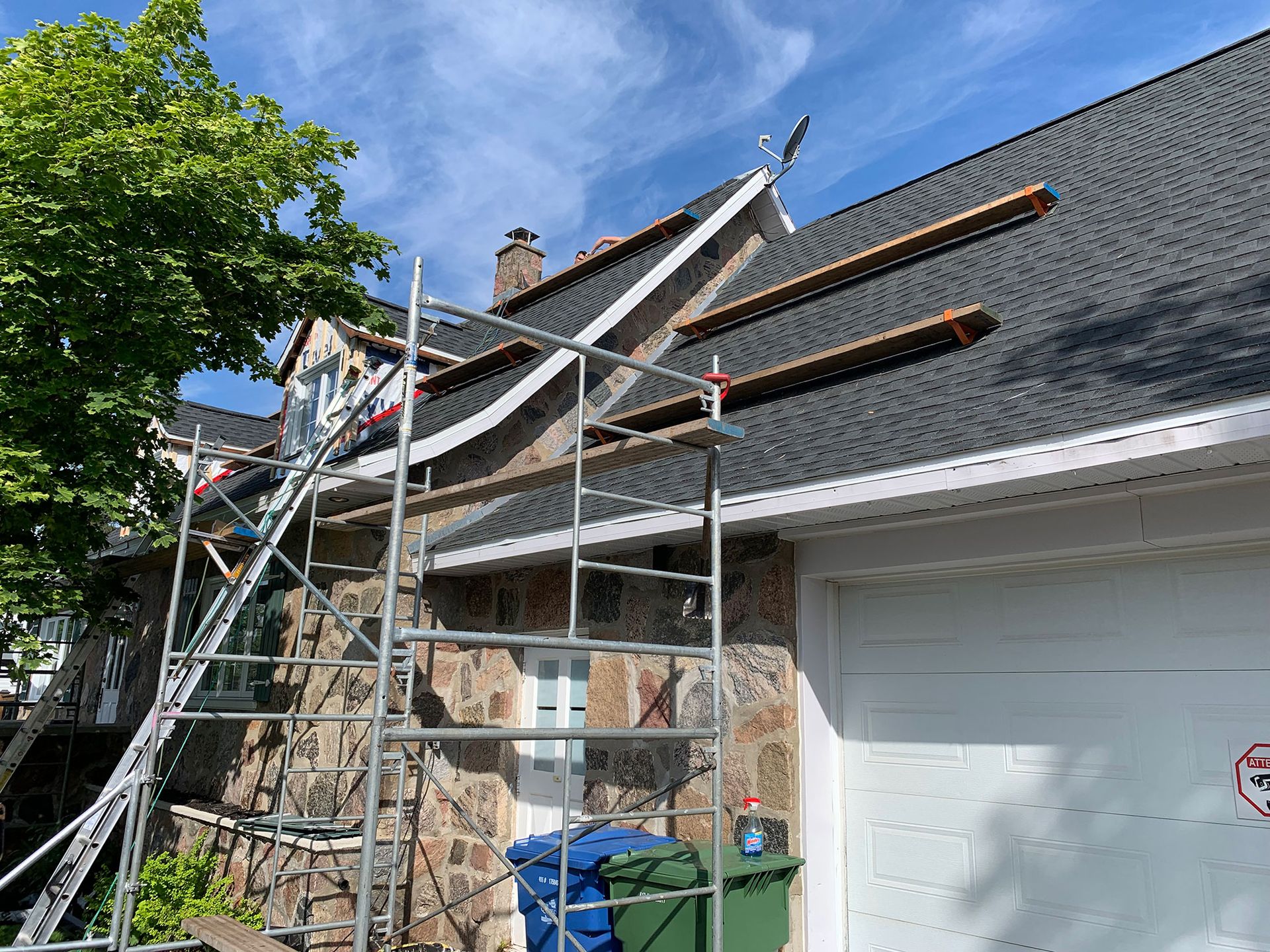 Un toit est en cours de réparation sur une maison avec un échafaudage.