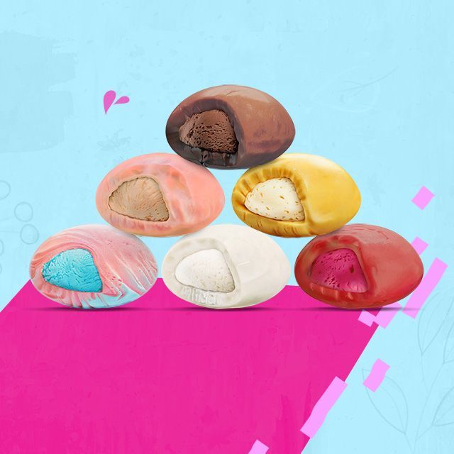 Una pirámide de bolas de helado sobre una superficie rosa.