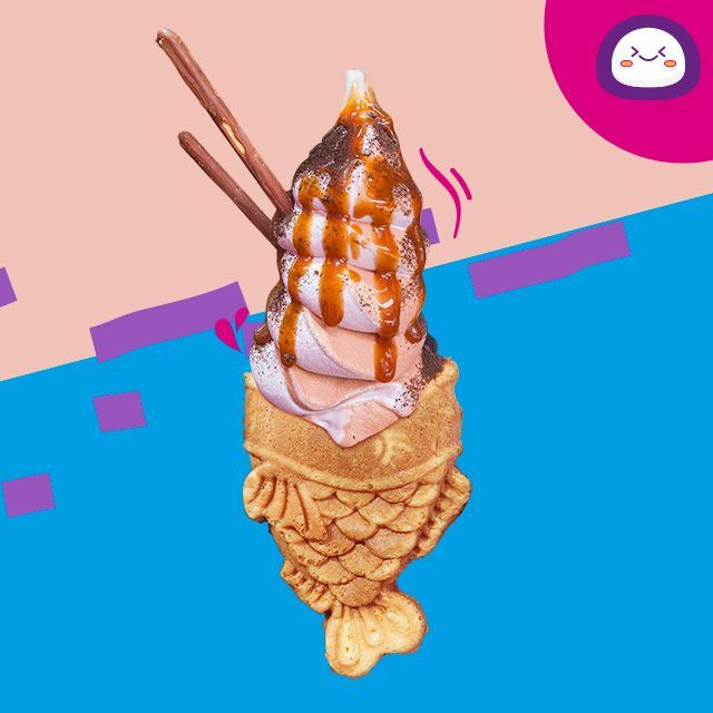 Una taza de arena mochi está sobre una mesa rosa.