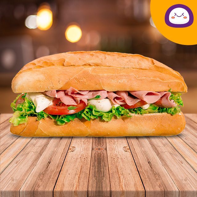 Un sándwich con pollo y verduras en una mesa de madera.