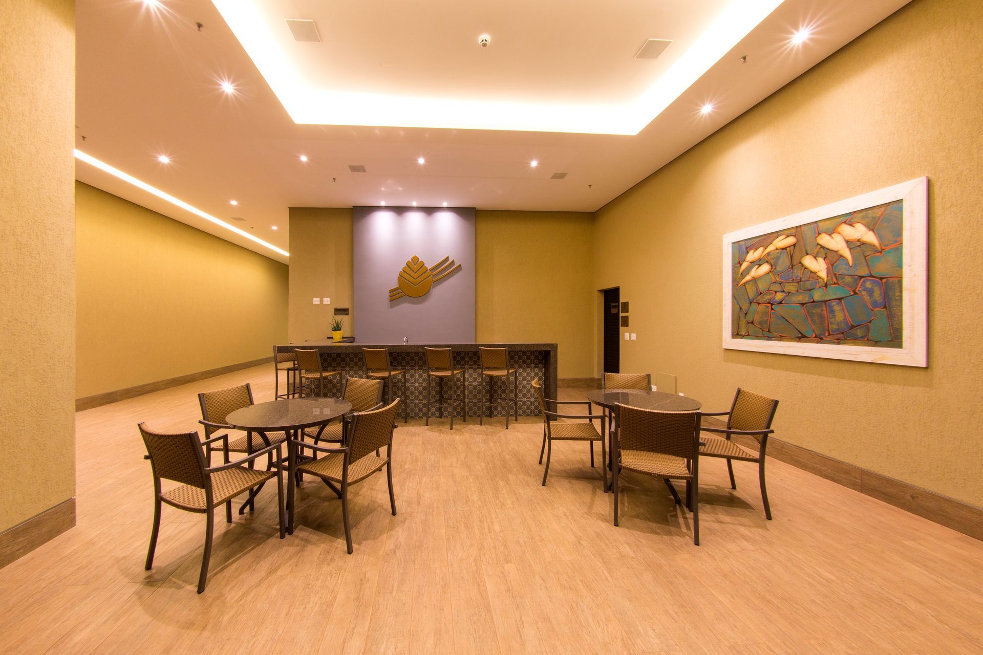 Uma sala com mesas e cadeiras e um quadro na parede