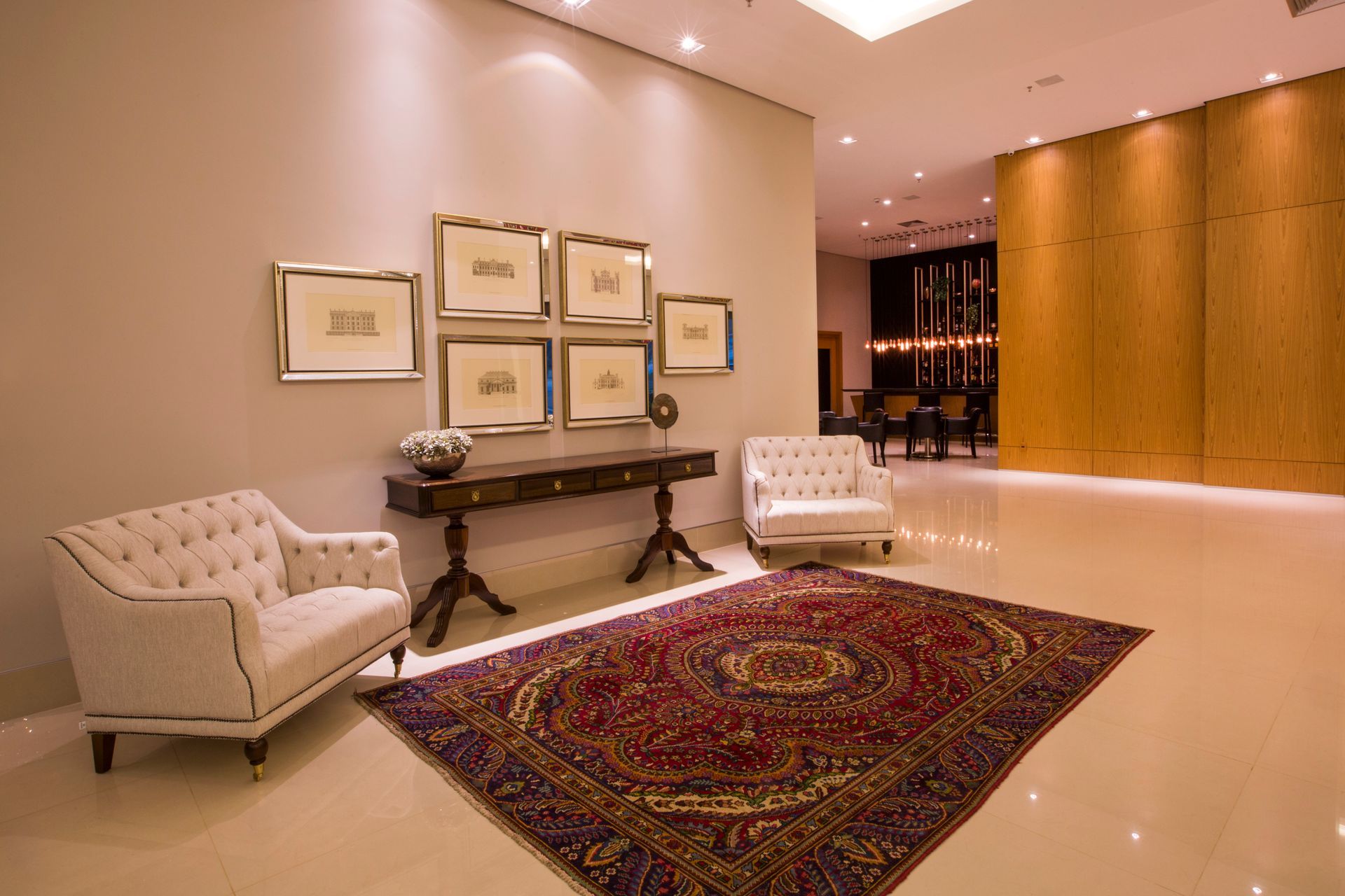 Uma sala de estar com um tapete, cadeiras e uma mesa.