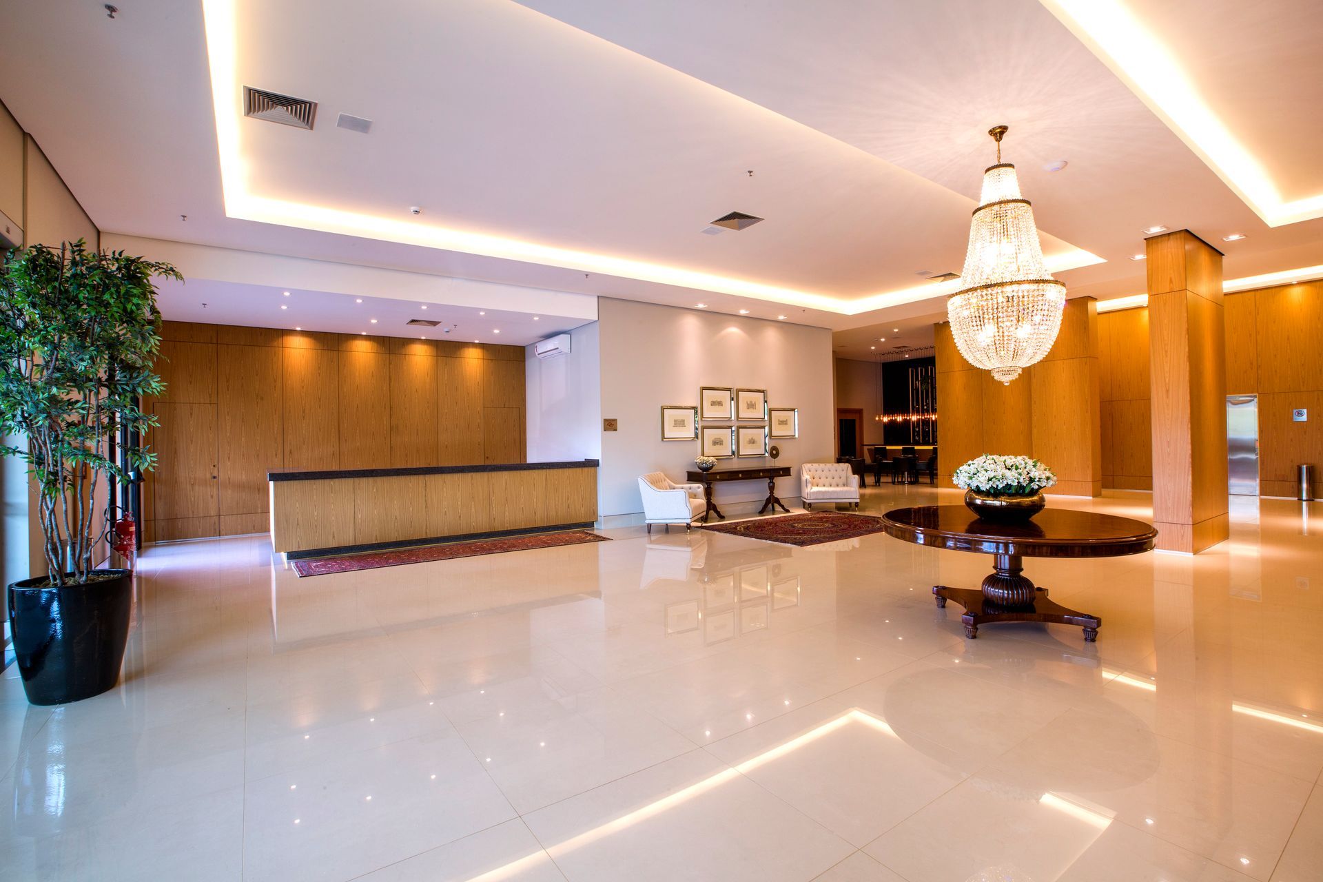 Um grande saguão com uma mesa, cadeiras e um lustre.