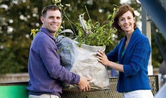Couple Throwing Trash in the Bag — The Rubbish Bag Co in Sunshine Coast, QLD
