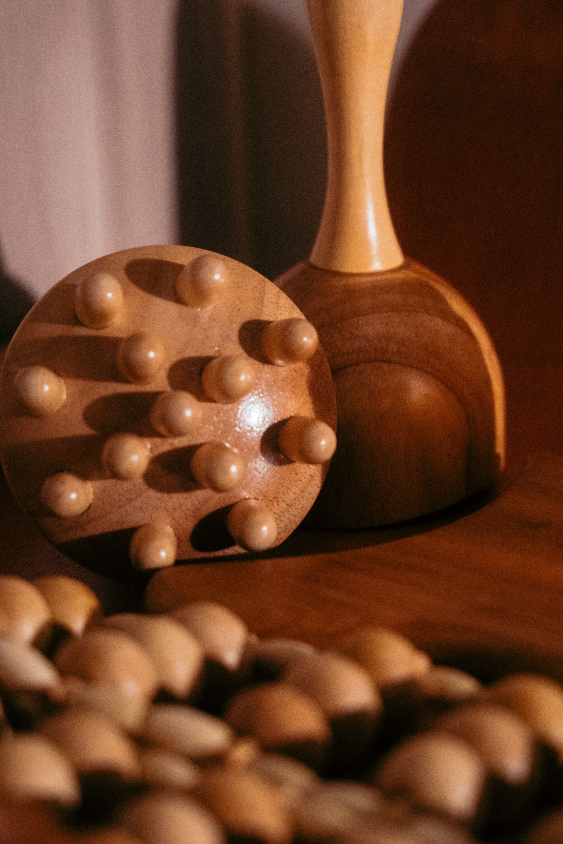 Due strumenti da massaggio in legno sono appoggiati su un tavolo di legno.