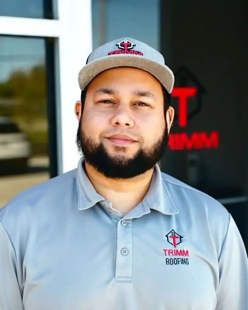A man with a beard wearing a hat and a trimm shirt