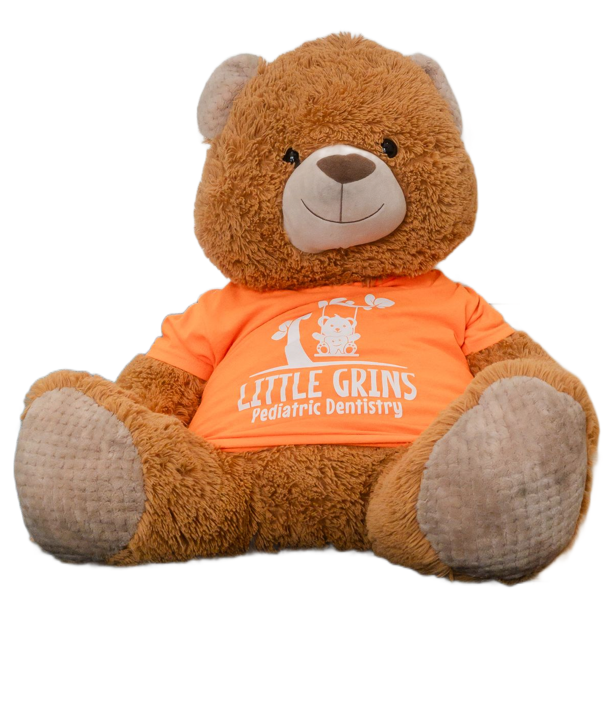 Brown teddy bear wearing an orange shirt with