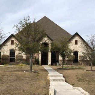 A large house with a pyramid shaped roof and a walkway leading to it.