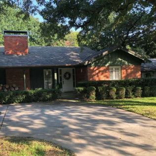A brick house with a chimney and a wreath on the front door.