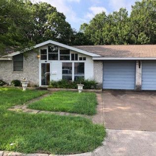 A house with a blue garage door and a large lawn in front of it.